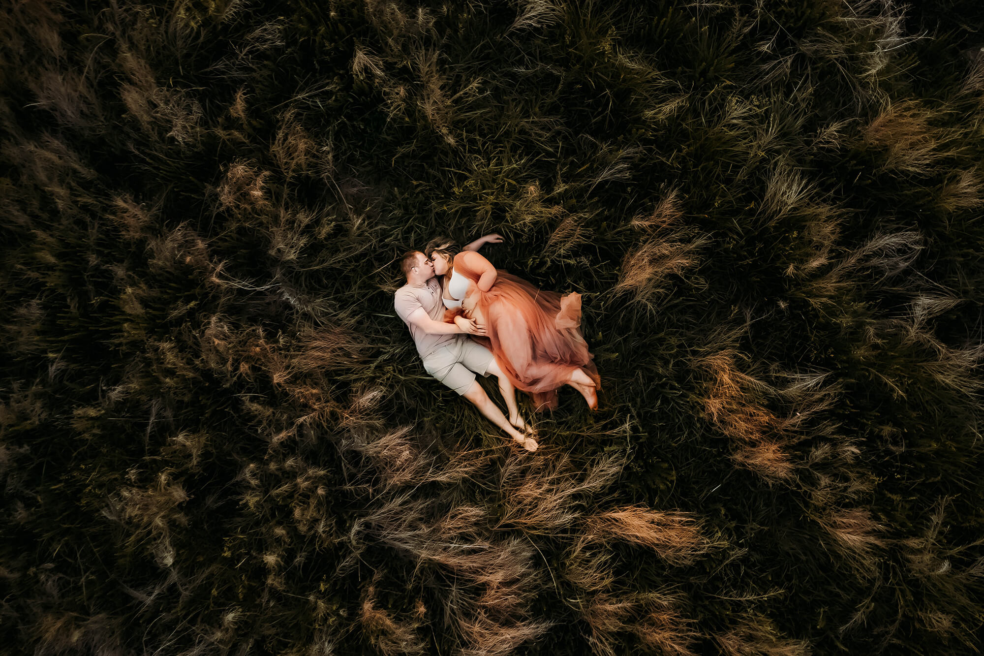 Springfield MO photographer captures pregnant couple cuddling in a field