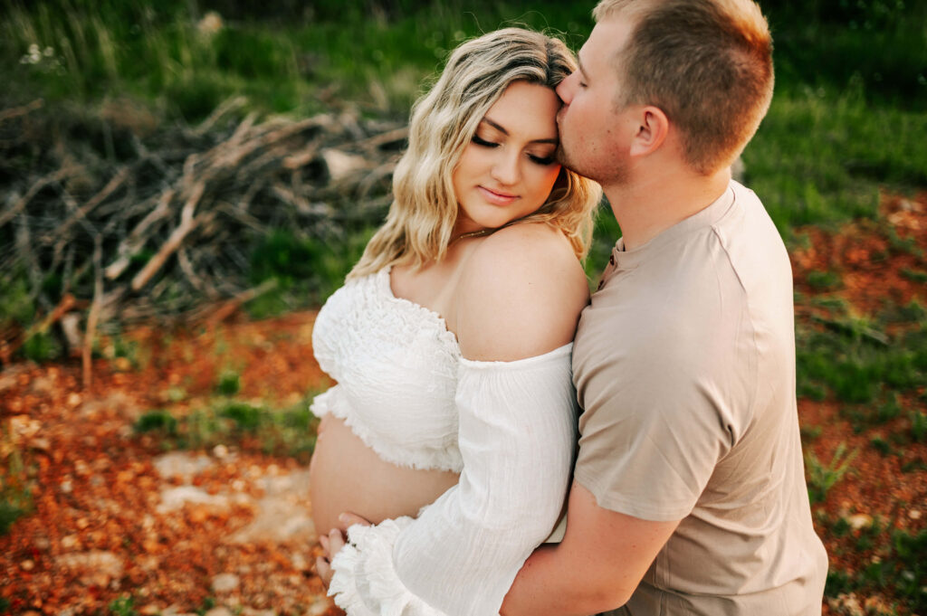 pregnant couple cuddling outdoors during Springfield MO maternity photography session