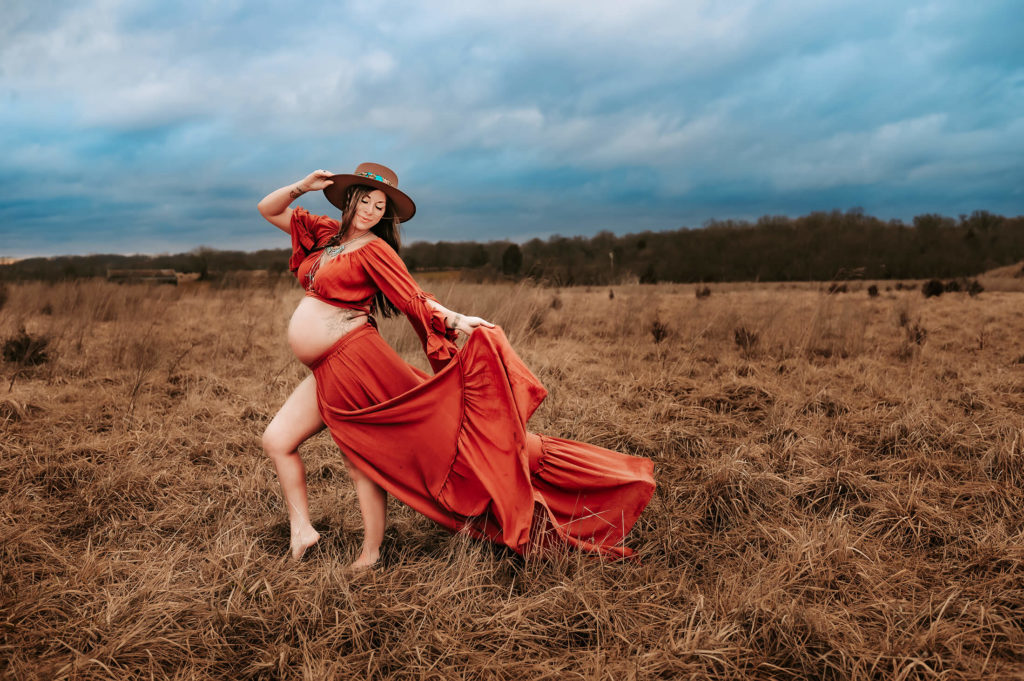 maternity photographer in Kansas City captures pregnant mom in field after prenatal massage in kansas city