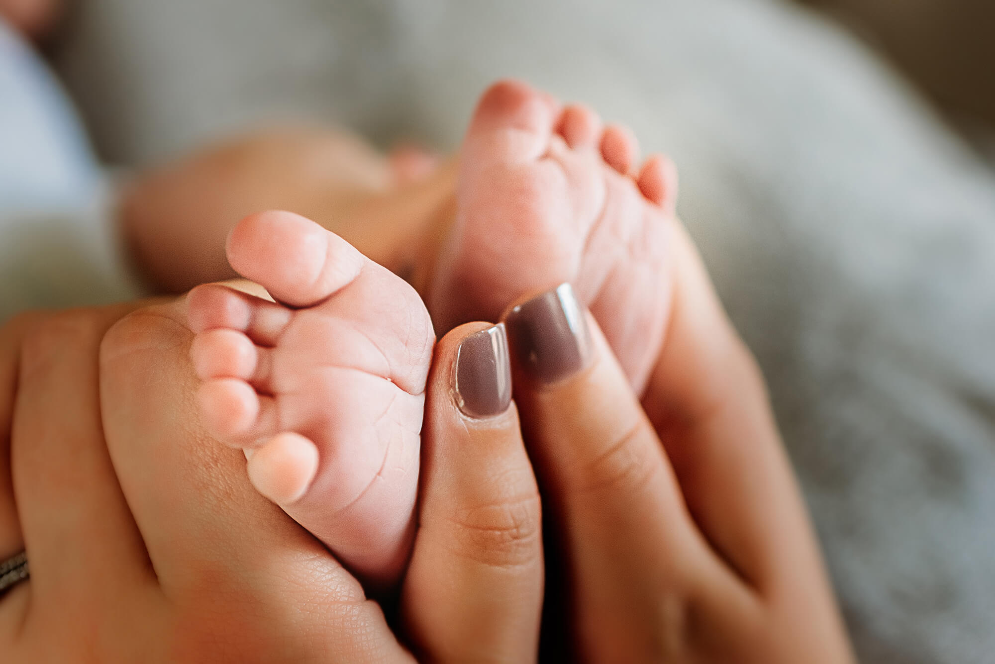 mom holding newborn baby feet captured by Kansas City newborn photographer Jessica Kennedy of The XO Photography