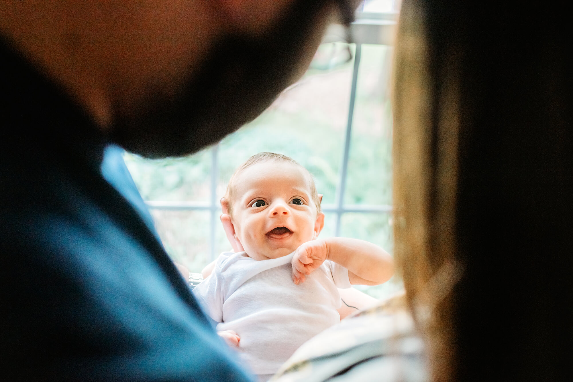 Overland Park newborn photographer captures parents smiling at newborn baby