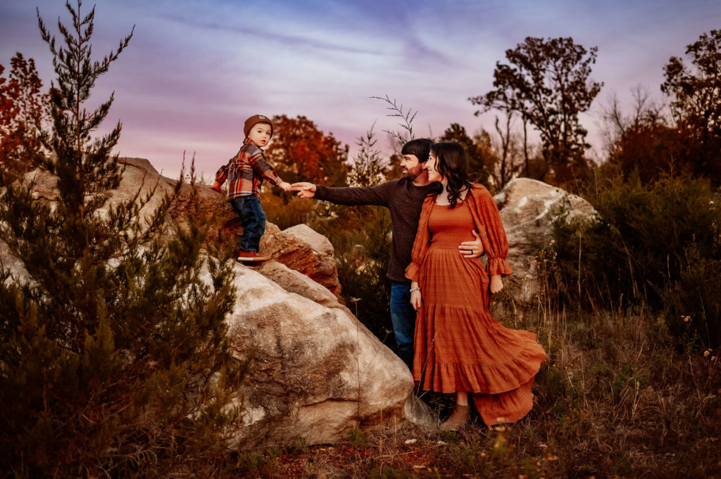 Jessica Kennedy of The XO Photography captures family portraits in Springfield MO of family climbing on rock at sunset
