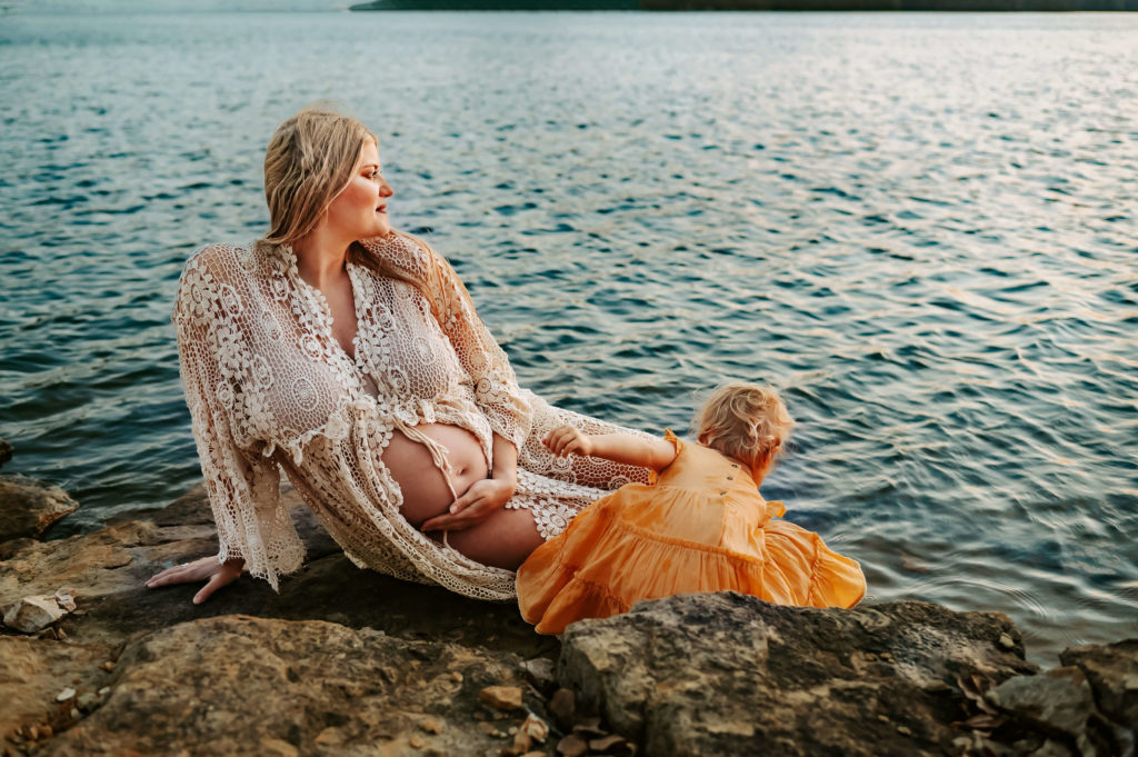 professional photographer in Branson Mo captures pregnant mom and daughter playing by Table Rock Lake