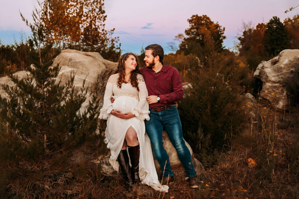 Kansas City maternity photographer captures pregnant couple sitting on rock