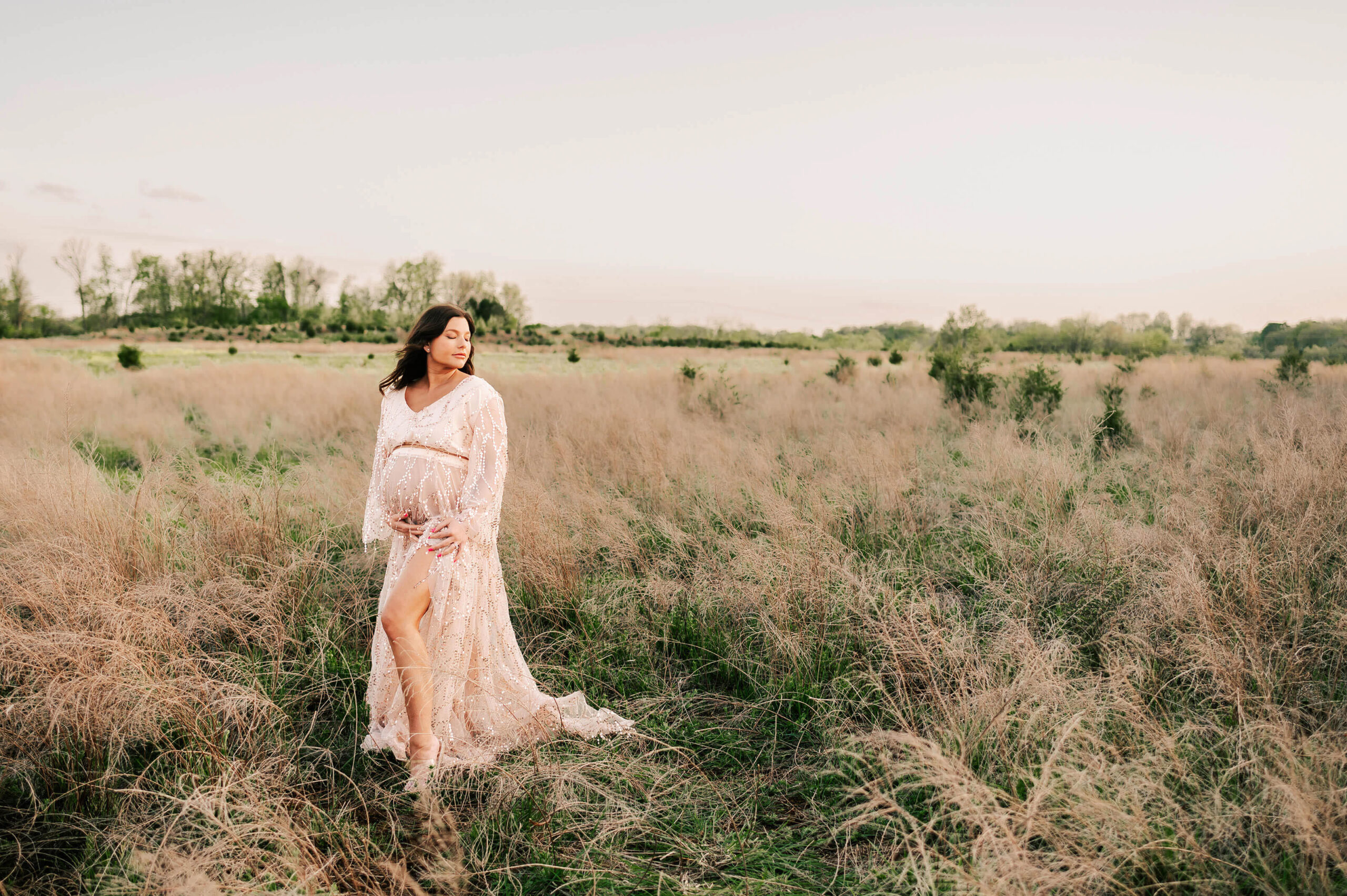 Springfield MO maternity photographer captures pregnant mom standing in field at sunset