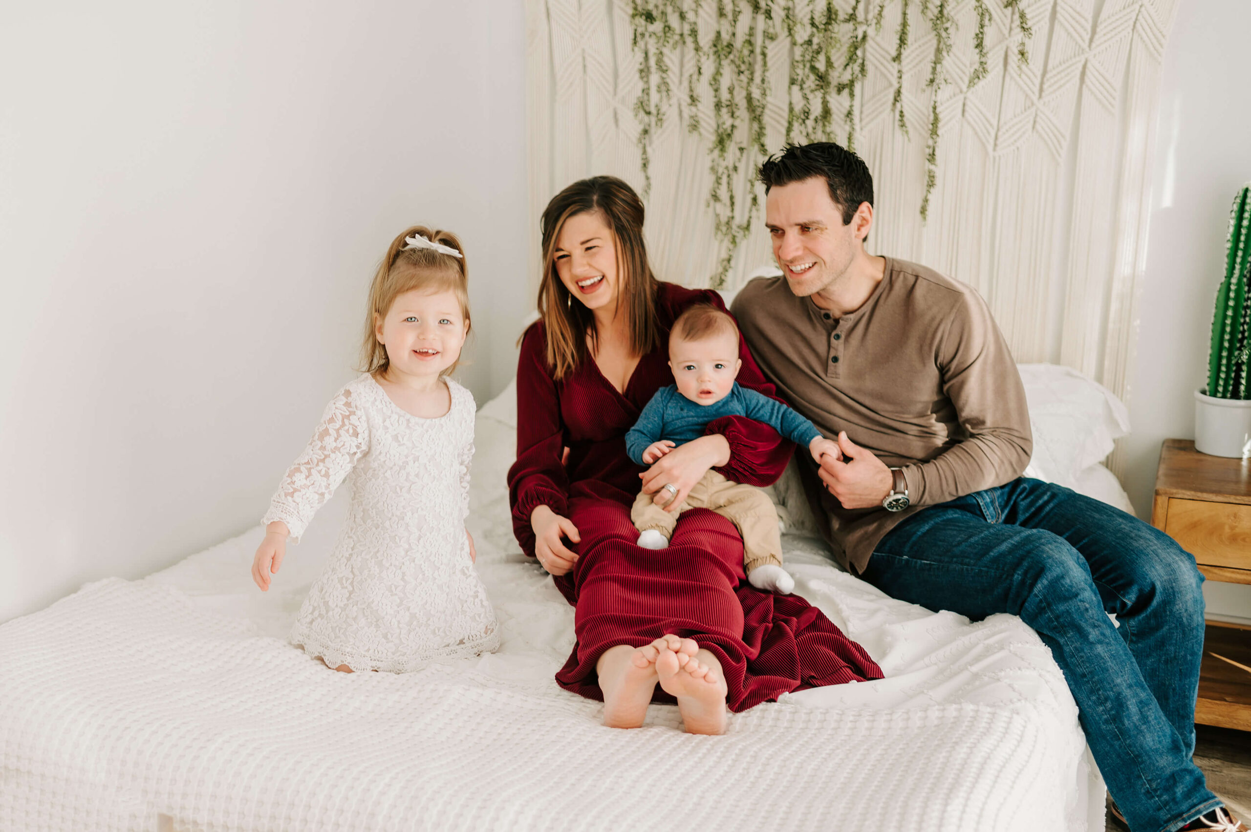 family portrait of family cuddling in bed in photography studio in Springfield MO