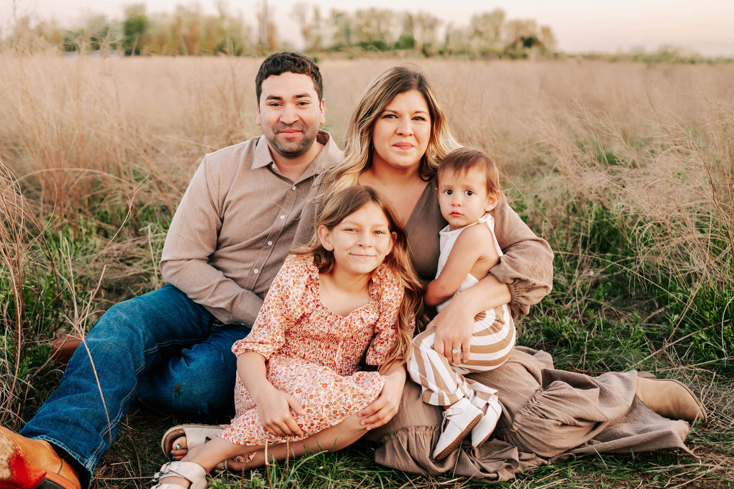 family sitting in field captured by Springfield MO family photographer The XO Photography