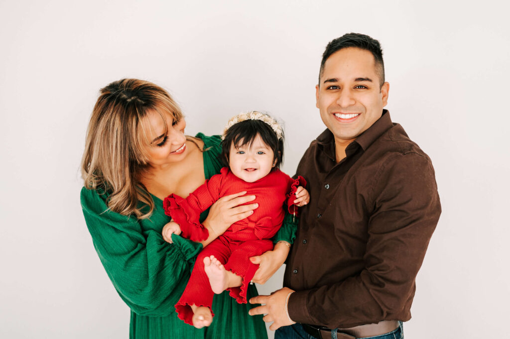parents holding smiling toddler in Springfield MO family photography studio