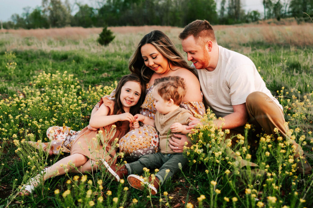 family cuddling in flower field during Springfield MO family photography session