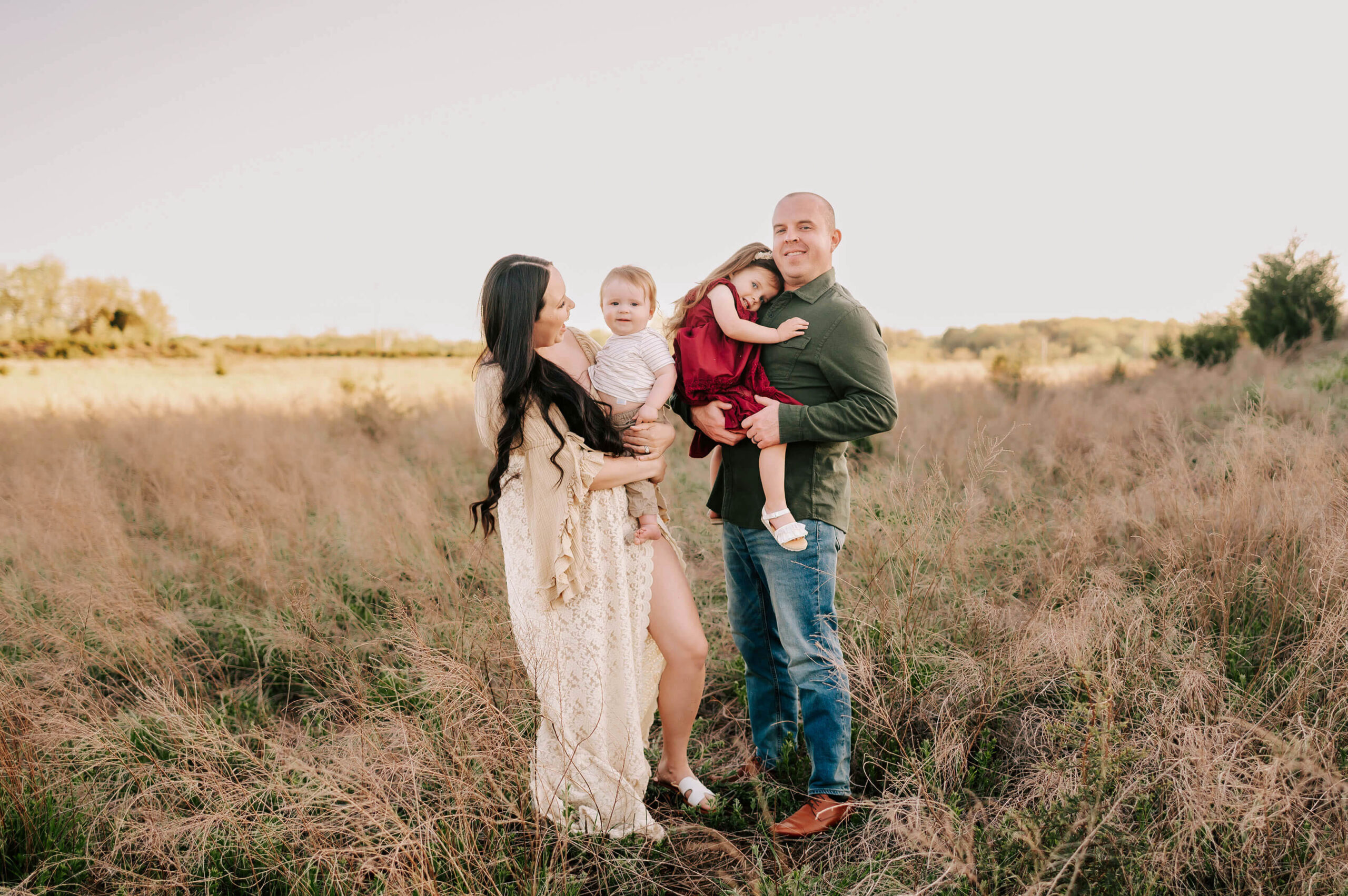 family cuddling in field during Springfield MO family photographer The XO Photography