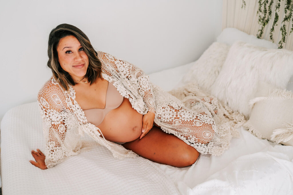 Springfield MO maternity photographer captures pregnant mom in robe laying on bed