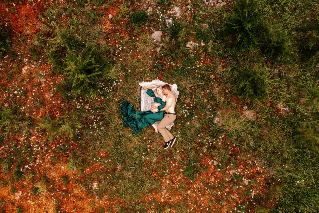 drone photo of pregnant couple laying in field during Kansas City maternity session