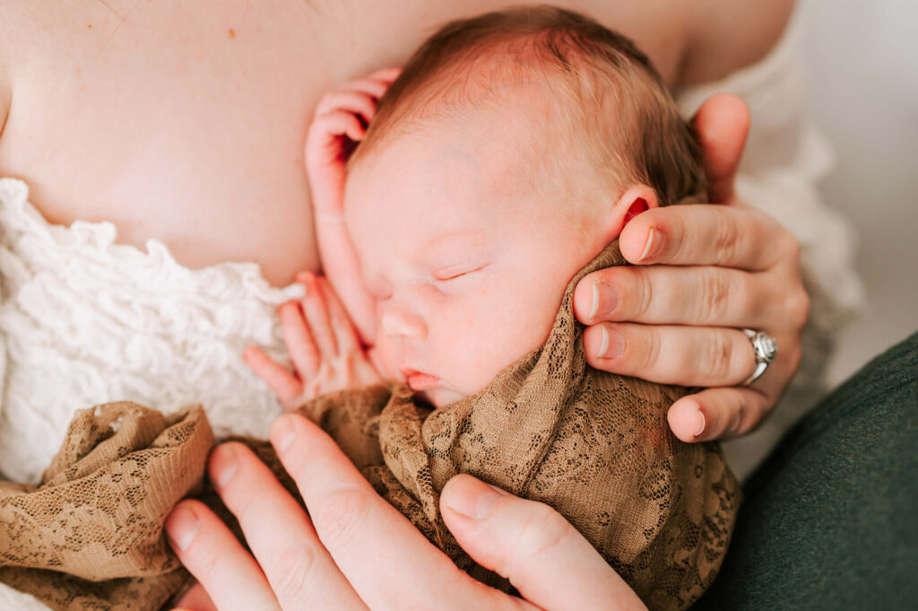 Kansas city newborn photographer captures mom holding newborn baby in brown lace