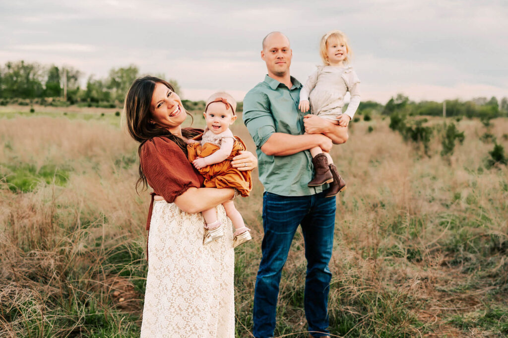 family standing in field captured by Springfield MO family photographer Jessica Kennedy The XO Photography