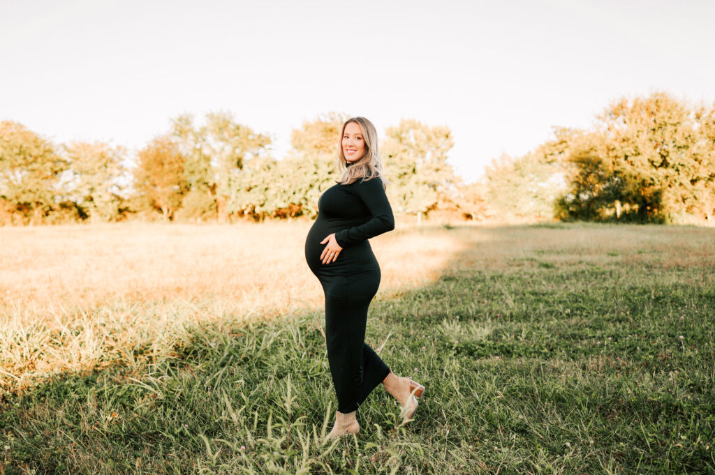 pregnant mom walking in field captured by Springfield MO maternity photographer Jessica Kennedy of The XO Photography