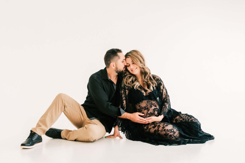 pregnant couple cuddling in maternity photography studio in Springfield MO