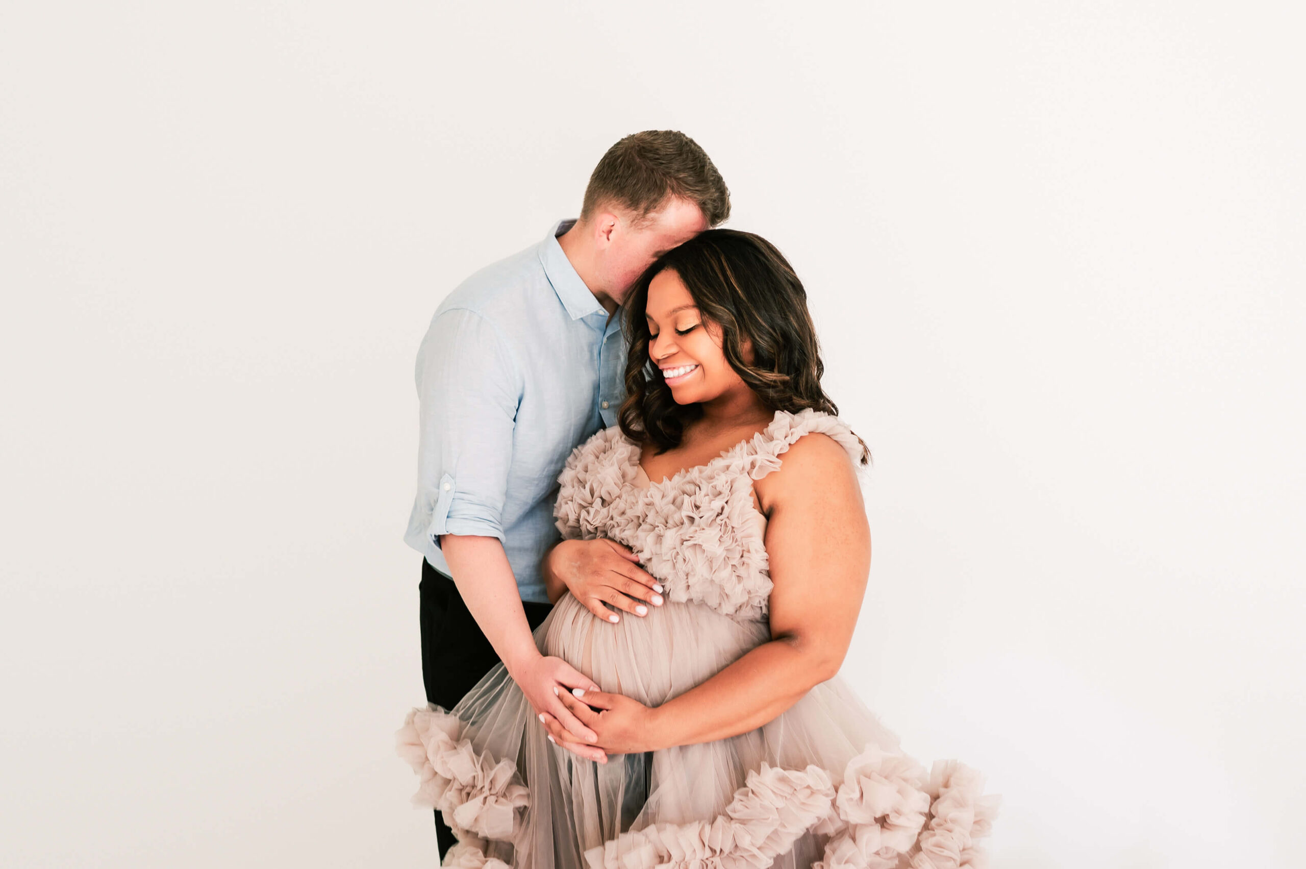 pregnant couple hugging in studio in Springfield MO