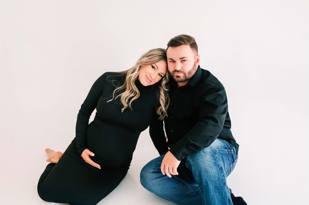 pregnant couple cuddling in photography studio