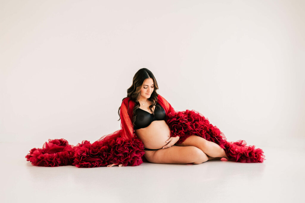 pregnant mom in maternity photography studio in Springfield MO holding her baby bump