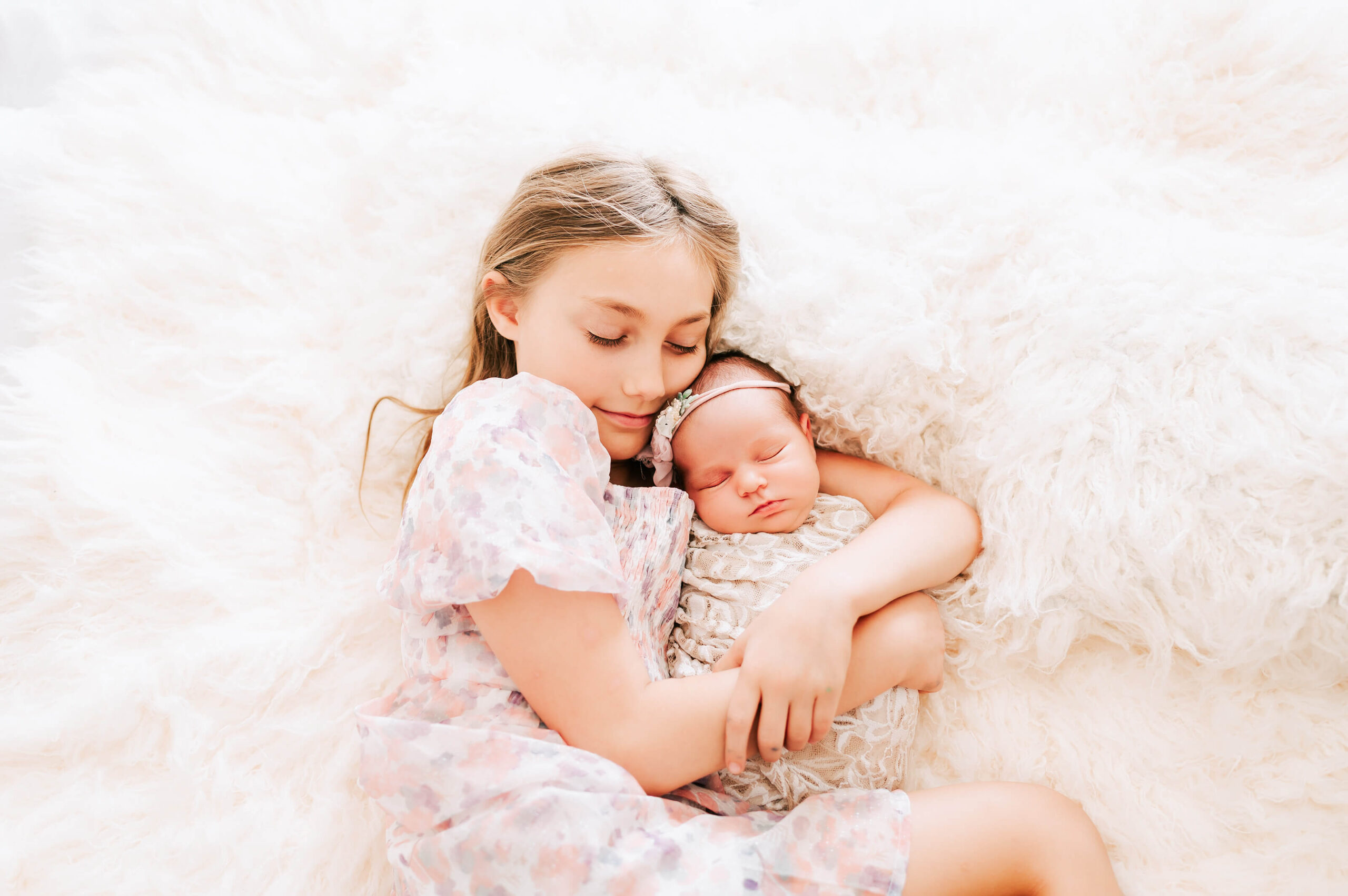 big sister hugging baby sister