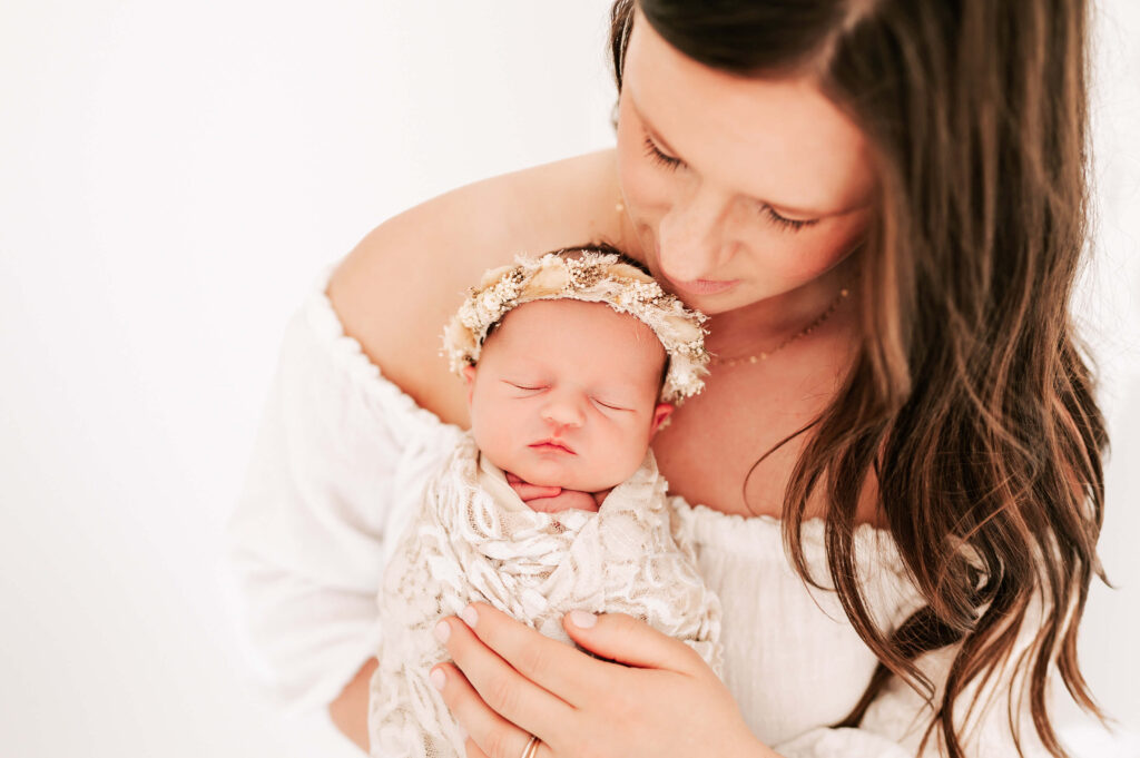 mom holding sleeping newborn baby girl on chest