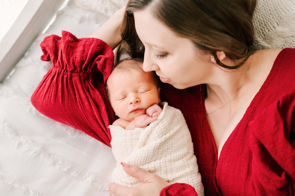 mom holding newborn baby in bed captured by Branson newborn photographer Jessica Kennedy of The XO Photography