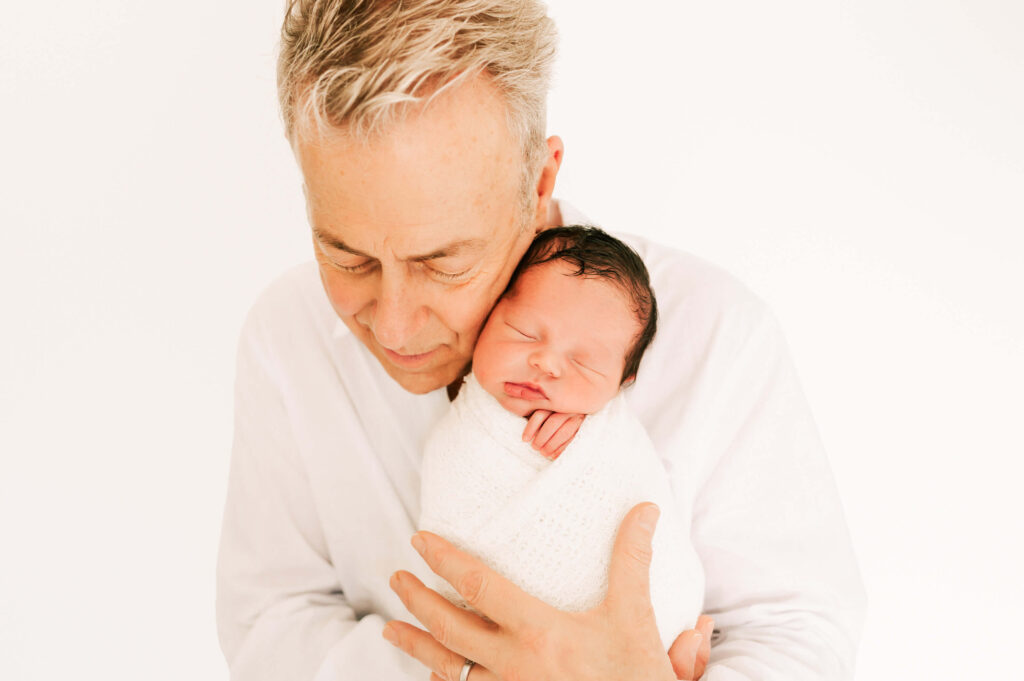 dad holding sleeping newborn baby boy captured by Springfield MO newborn photographer Jessica Kennedy of The XO Photography